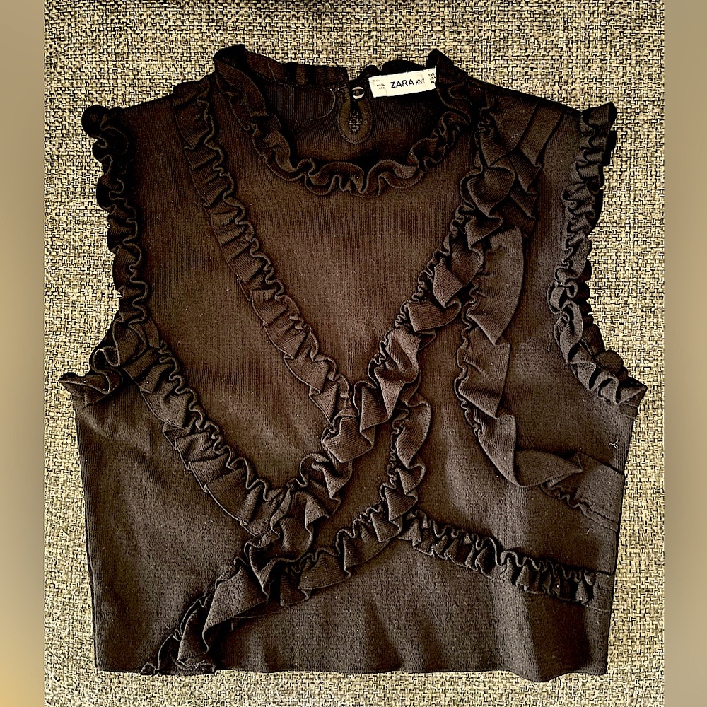Zara, worn, black sleeveless knit top with small ruffle details. Women size M